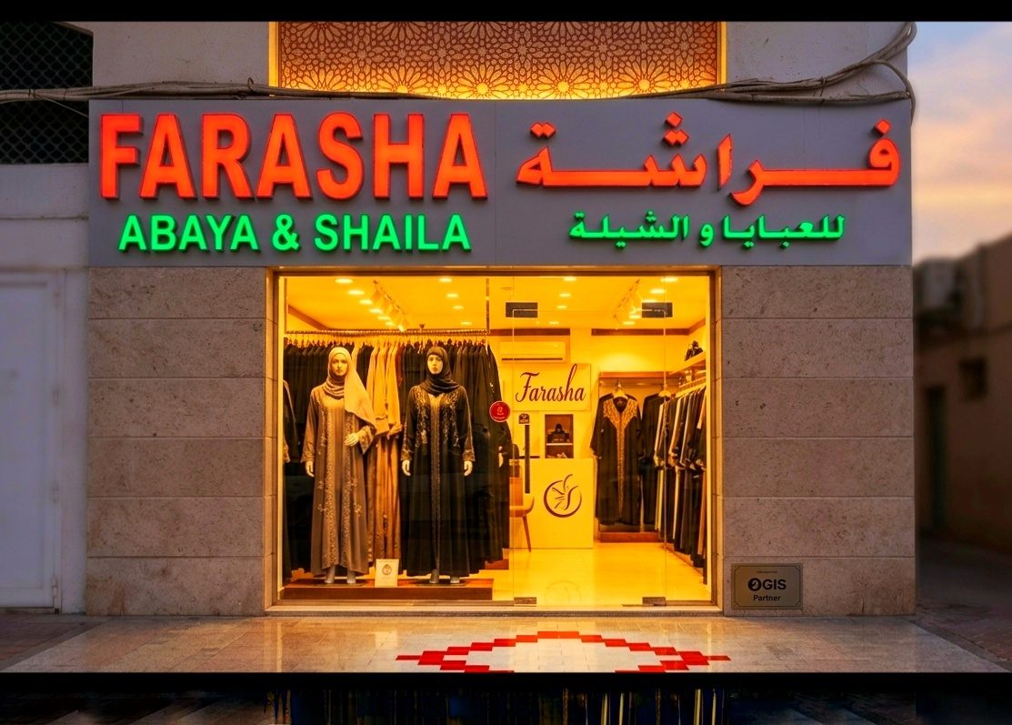 The Farasha Abaya & Shaila storefront in Al Danah, Abu Dhabi, lit at dusk